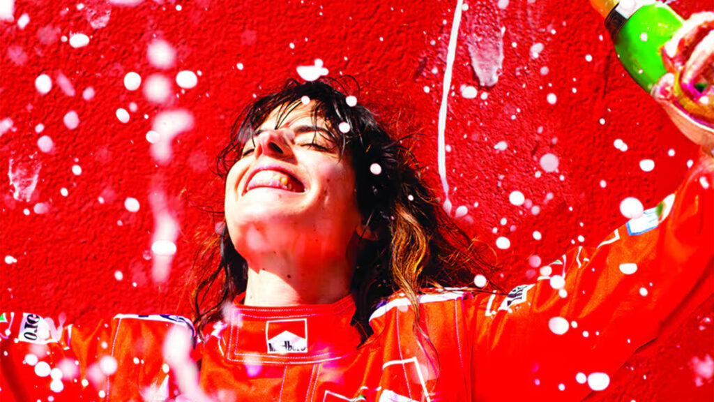 Femme joyeuse dans une tenue de course automobille Ferrari