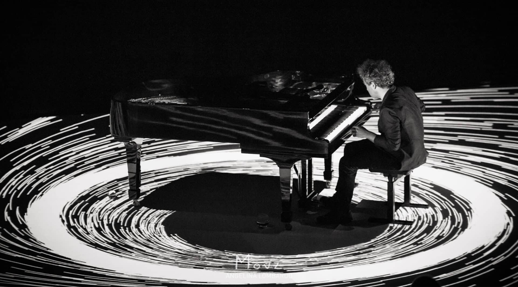 pianiste au milieu d'un cercle lumineux sur scène